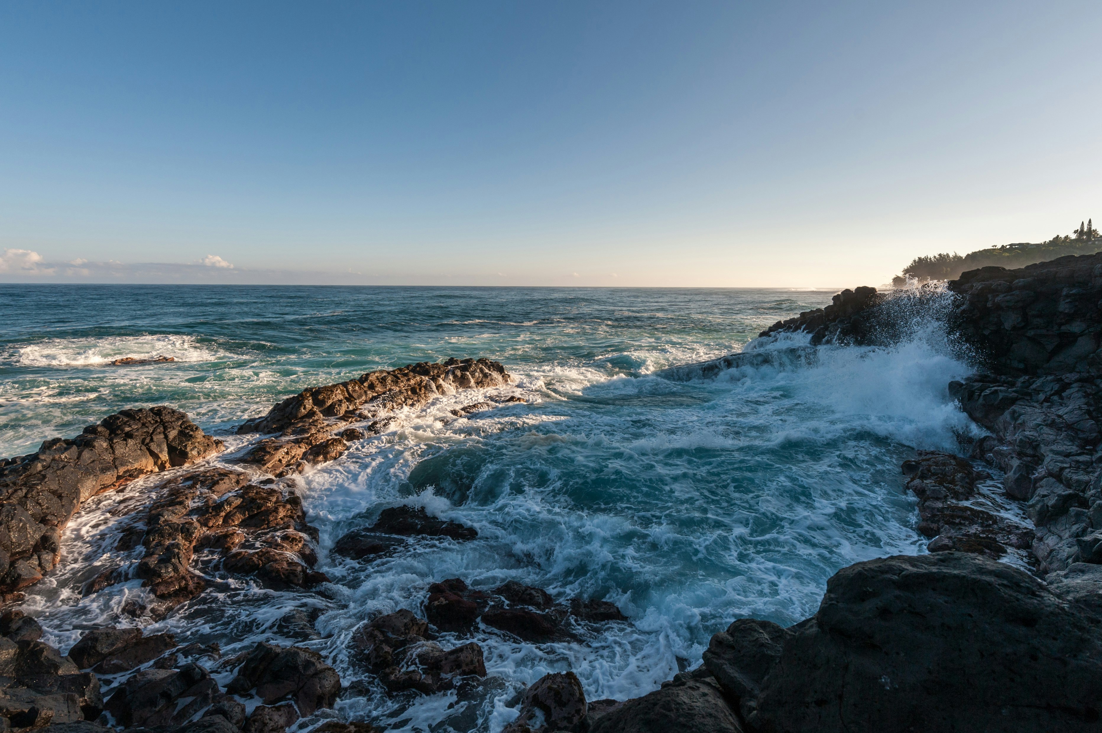 ocean waves hammering rock boulders